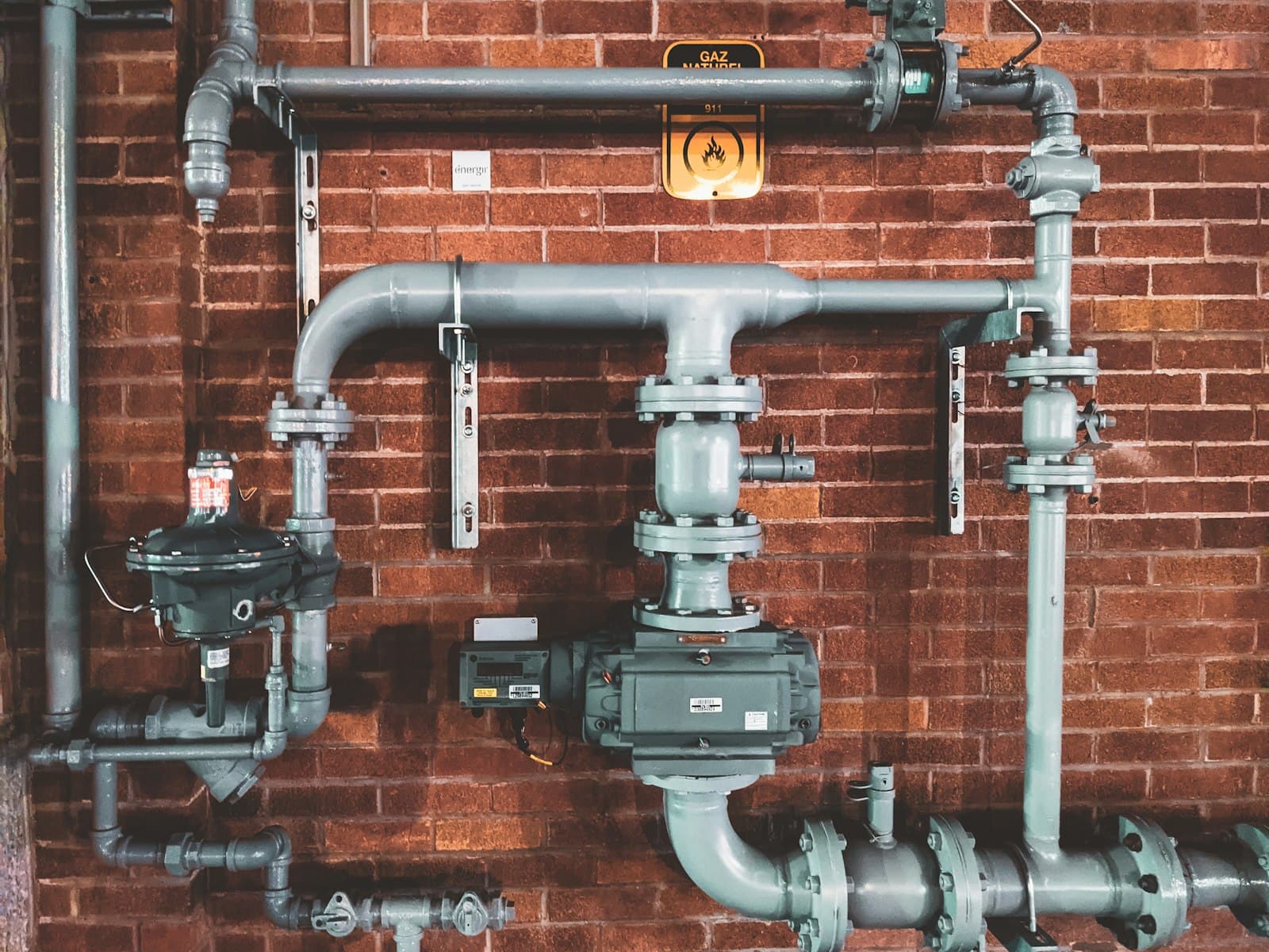 Industrial drain and sewer pipework on a brick wall