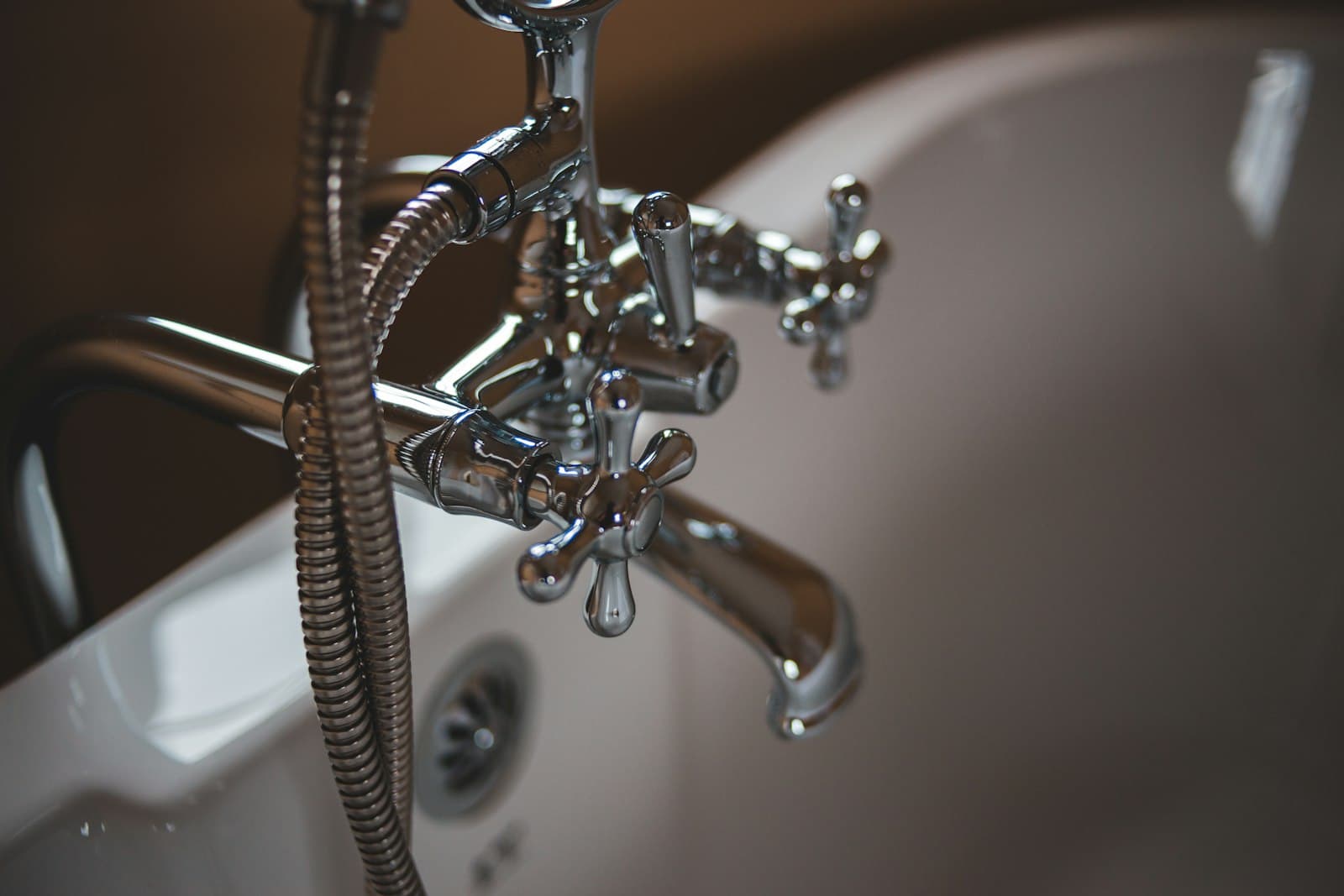 Macro detail of a chrome faucet and water lines